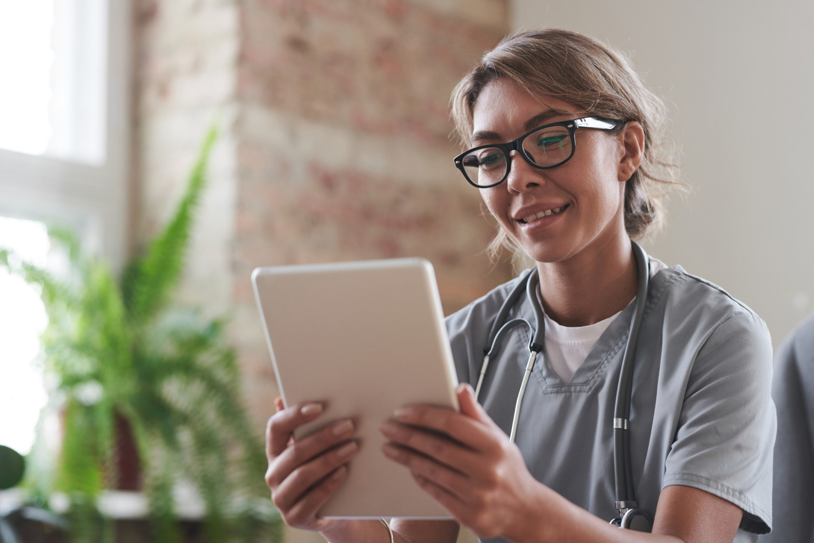 Health professional looking at tablet device.